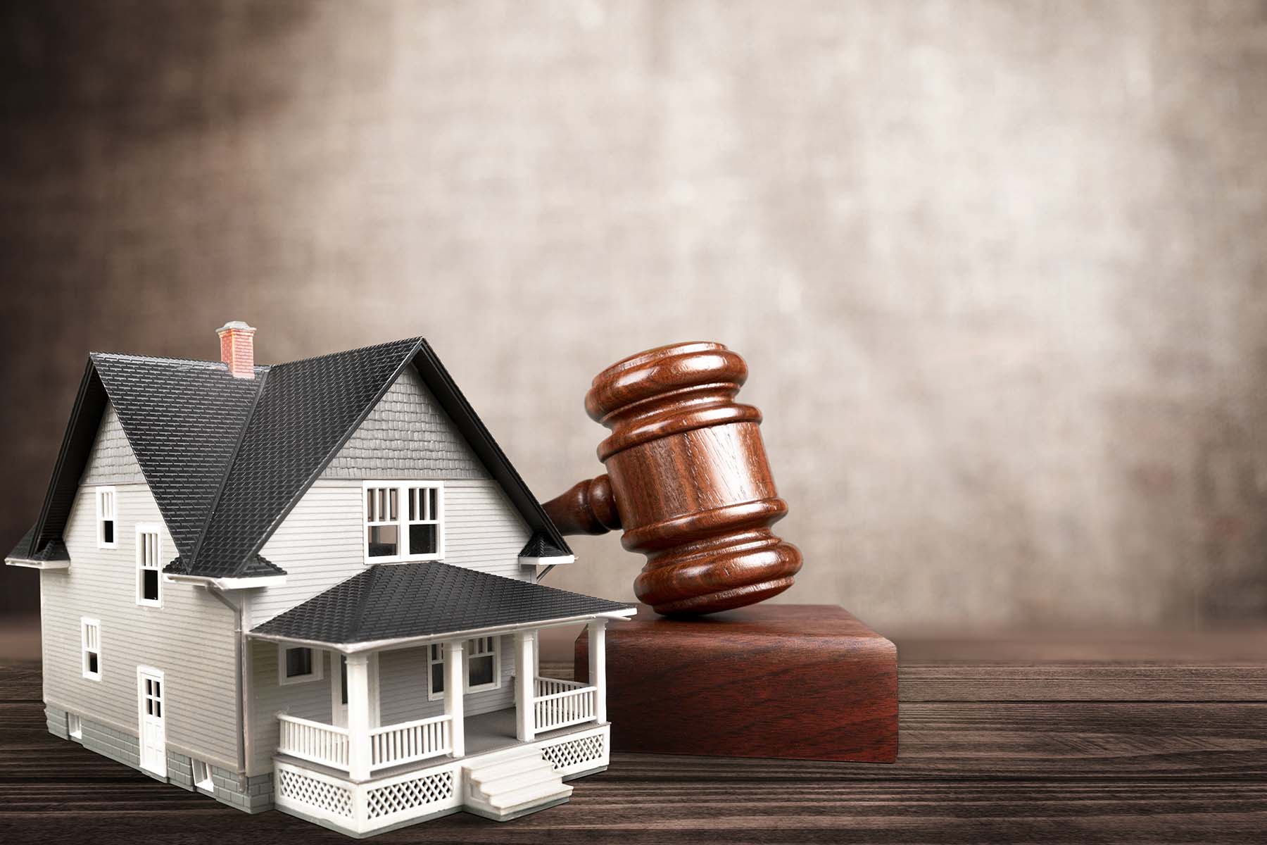 Miniature house and gavel representing real estate law